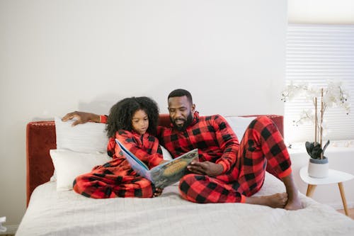 Free Man Reading Book to His Daughter Stock Photo