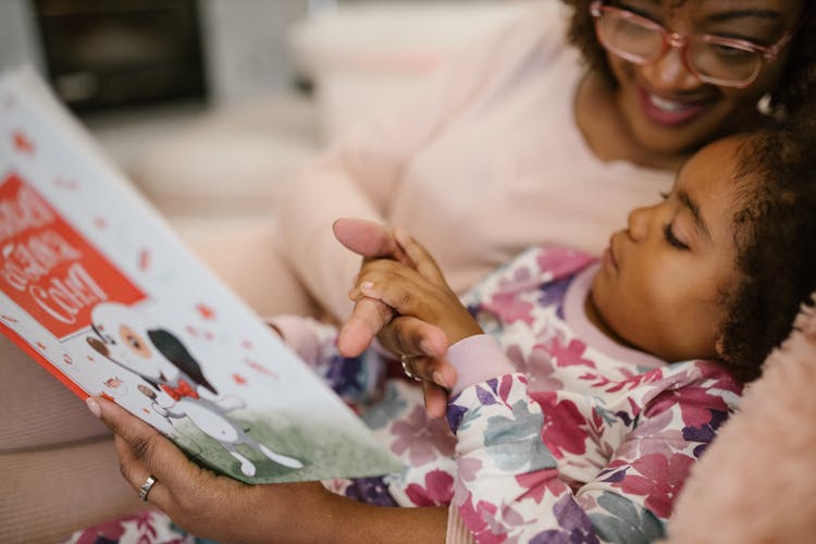 Close Up On Daughter Reading Book With Mother