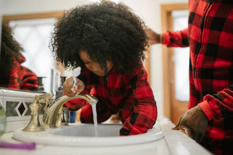 Father Assisting Child While Dental Hygiene