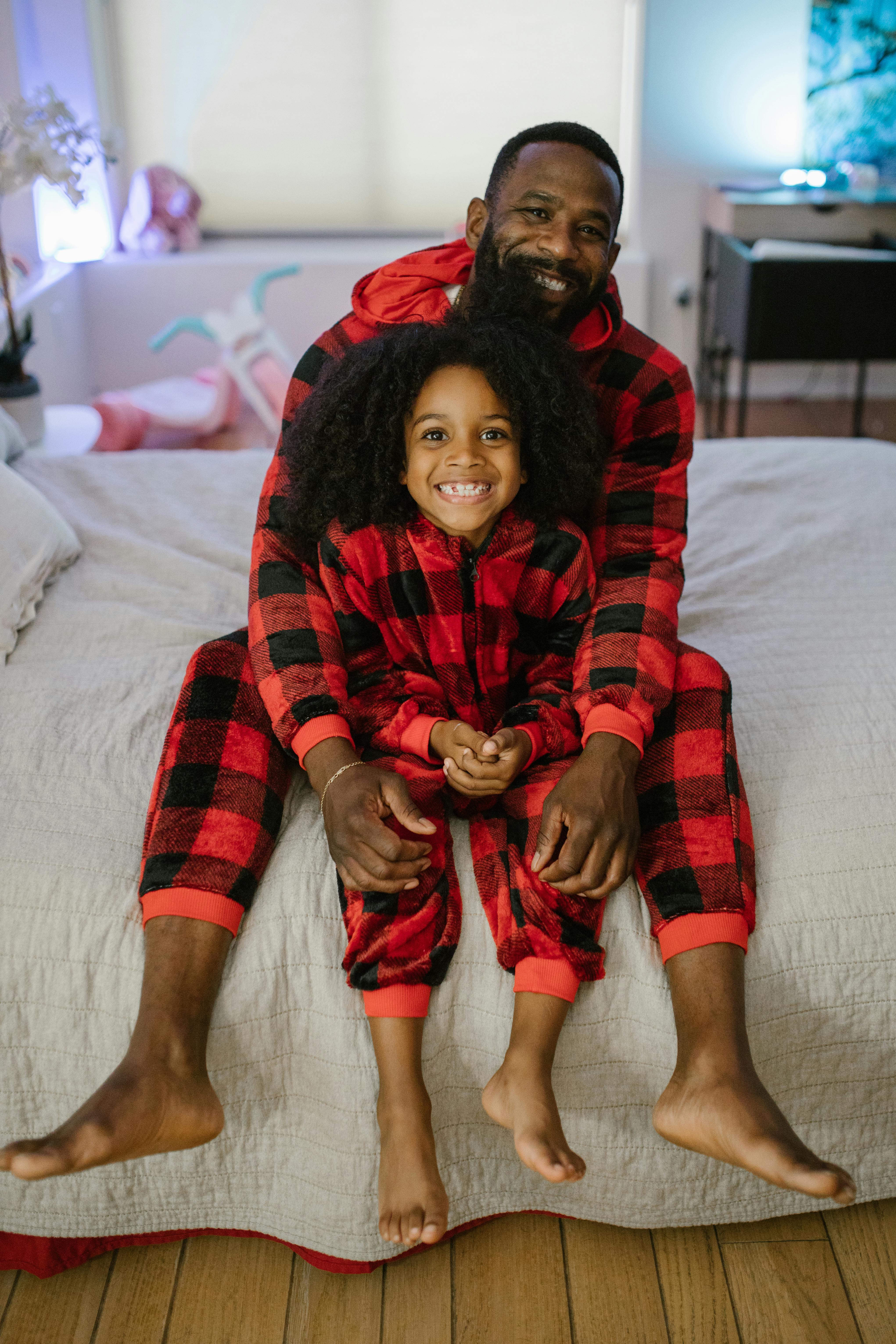 smiling daughter sitting on bed with father