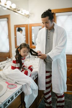 Father combs daughter's hair during morning routine in cozy home setting.