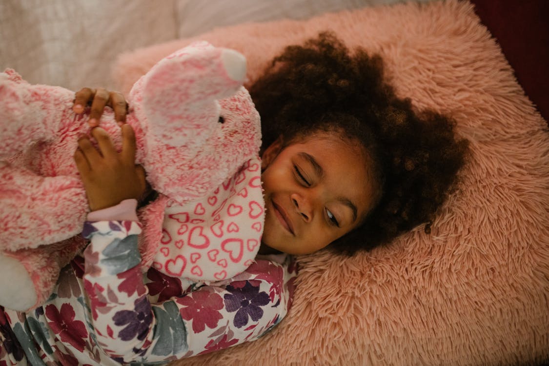 Free Child Embracing Toy in Bed Stock Photo