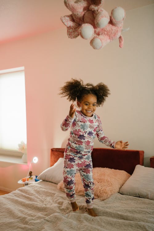 Happy Child Jumping on Bed