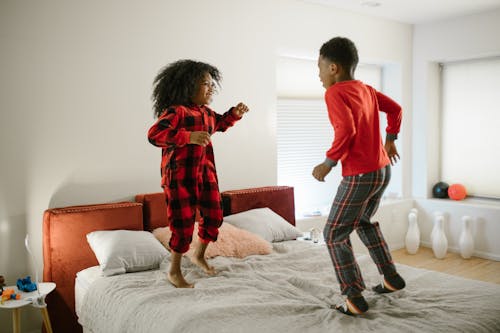 Brother Jumping on Bed with Sister