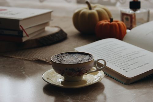 Free A warm autumn scene with coffee, pumpkins, and books on a table. Stock Photo