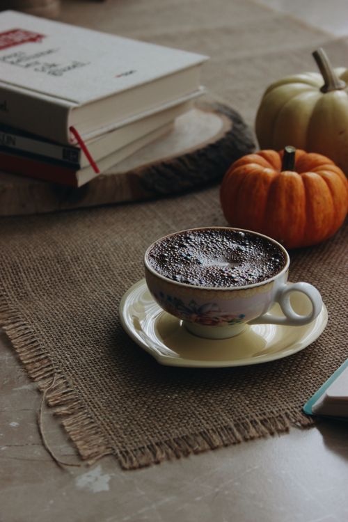 Free A cozy autumn setting with coffee, books, and pumpkins on burlap indoors. Stock Photo