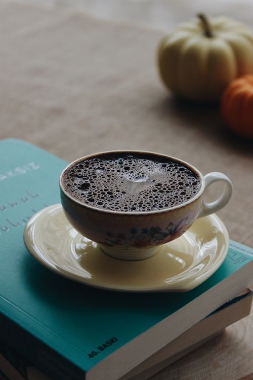Free Charming autumnal setup with a cup of black coffee, books, and pumpkins on a cozy table. Stock Photo