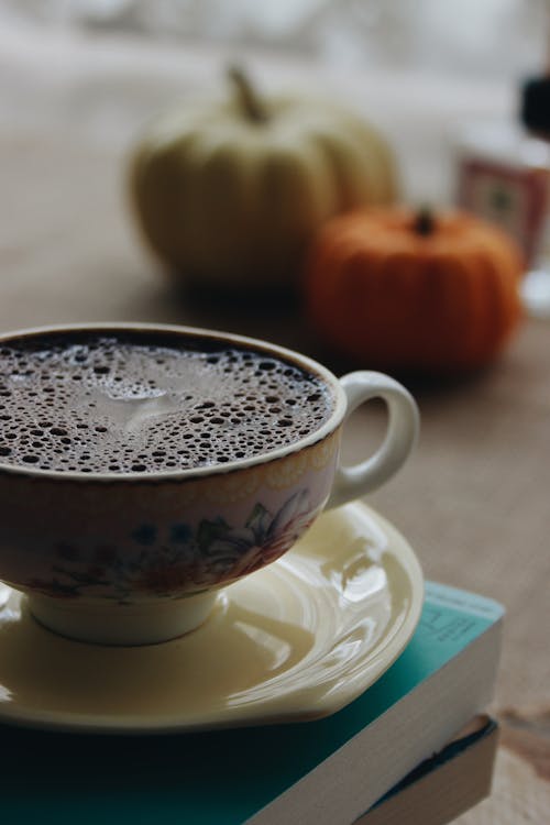 Free White Ceramic Cup With Chocolate Drink Placed on Top of Stack of Books Stock Photo