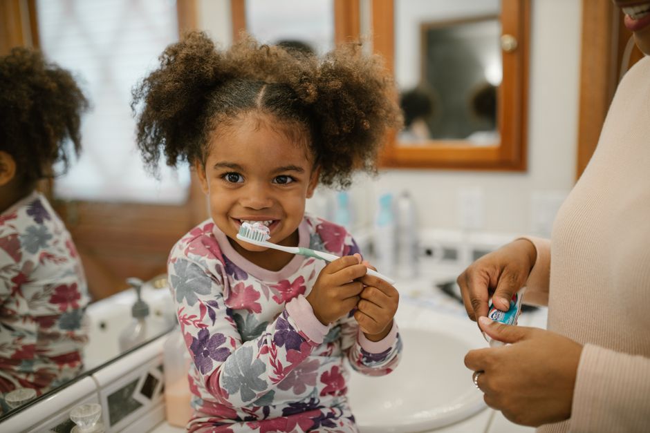 Photo by RDNE Stock project on Pexels Young girl with curly hair brushing teeth supervised by parent in a home bathroom. - Photo by RDNE Stock project on Pexels