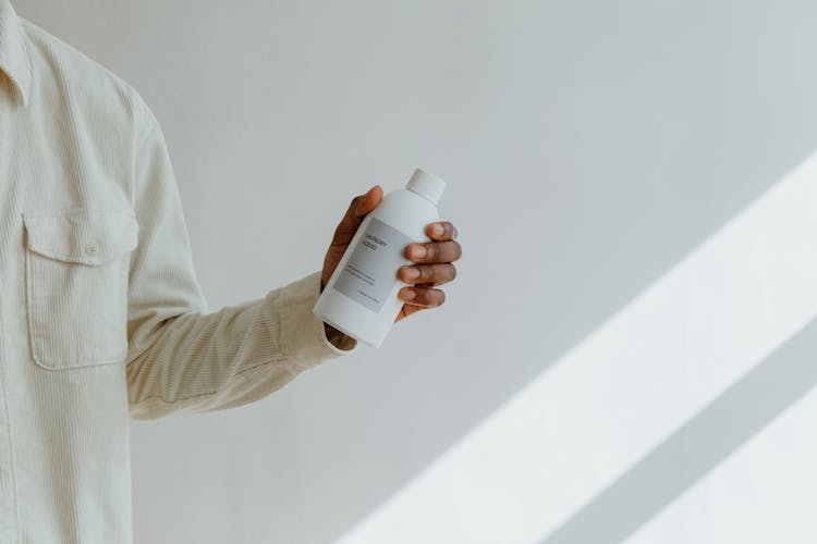 Man In Shirt Holding Plastic Bottle Of Cleaning Product In Hand