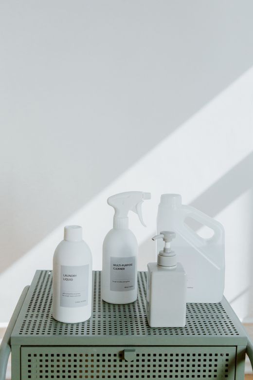 Spray bottles and cleaning supplies lined up in soft daylight