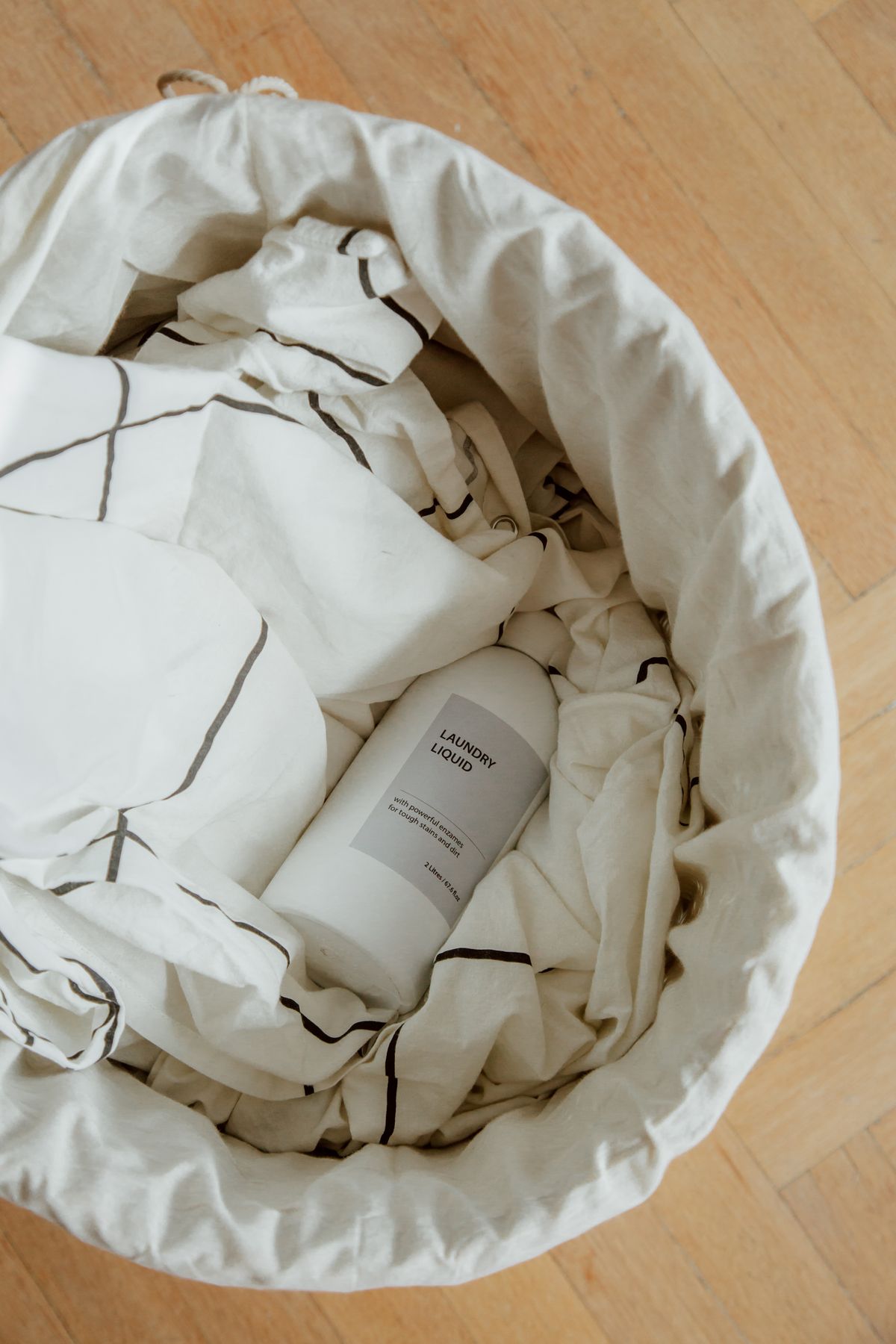 Laundry basket with fabrics and a household cleaning bottle