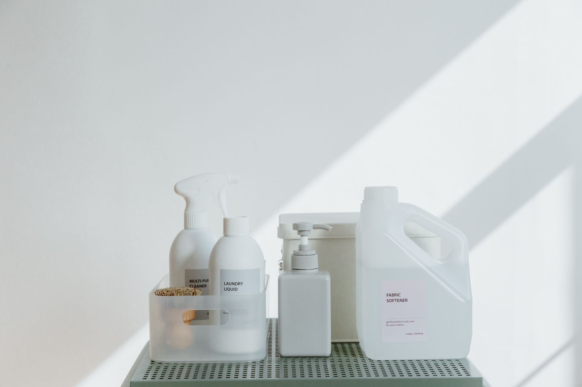 Prateleira organizada com produtos de limpeza doméstica em frascos coloridos