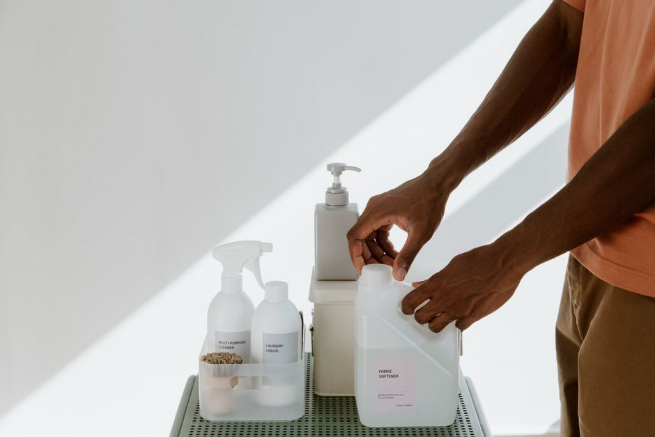 Man arranging cleaning products on a shelf, highlighting tidiness and organization. - Long Term Value and Maintenance