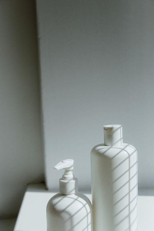 White bottles under a geometric shadow, photo by Ron Lach on Pexels