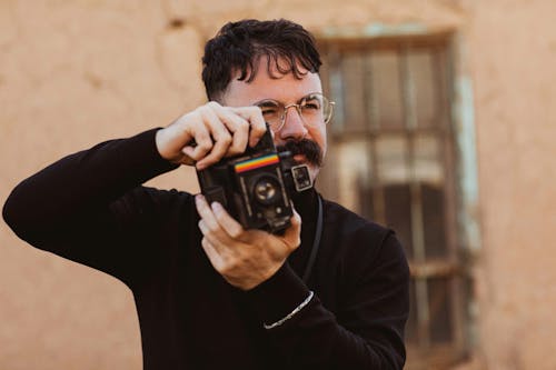 A Man in Black Sweater Holding a Camera