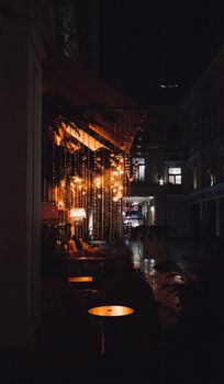 A cozy, warmly lit outdoor restaurant space in Houston, Texas at night.