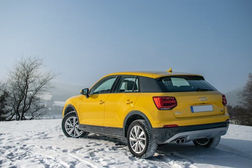 Free A Yellow Audi Car Parked on a Snow Covered Ground Stock Photo