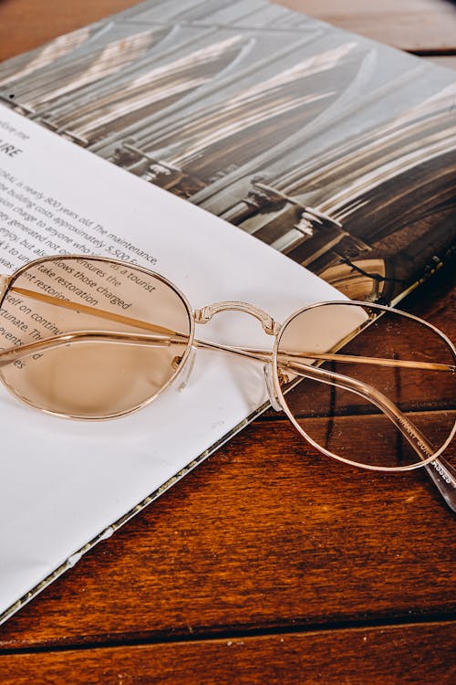 Free An Eyeglasses Near the Paper on a Wooden Table Stock Photo