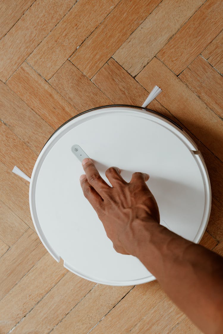 Man Touching Cleaning Robot 