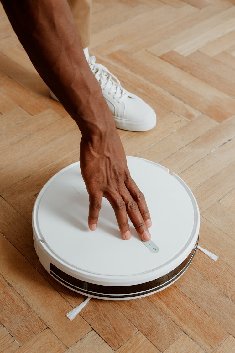 Man Touching Cleaning Robot 