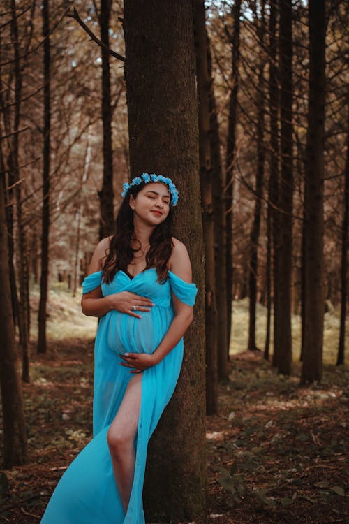 Free Woman in Blue Dress Standing in the Woods Stock Photo