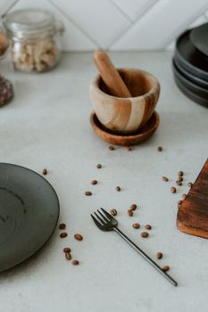 A cozy and rustic kitchen counter featuring scattered coffee beans and wooden kitchenware.