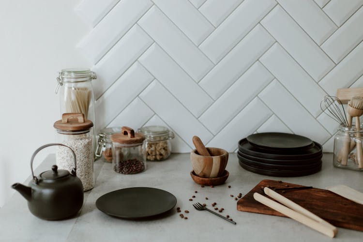 Messy Kitchen Counter With Plates, Mortar And Cutting Board