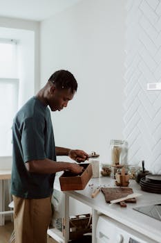 Adult man organizing kitchen items in a stylish modern kitchen.