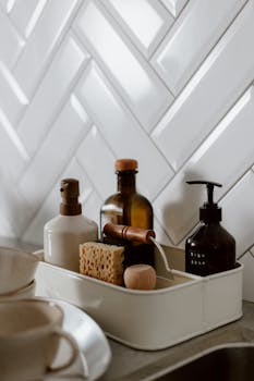 Stylish kitchen counter setup with soap and cleaning supplies in a modern setting.
