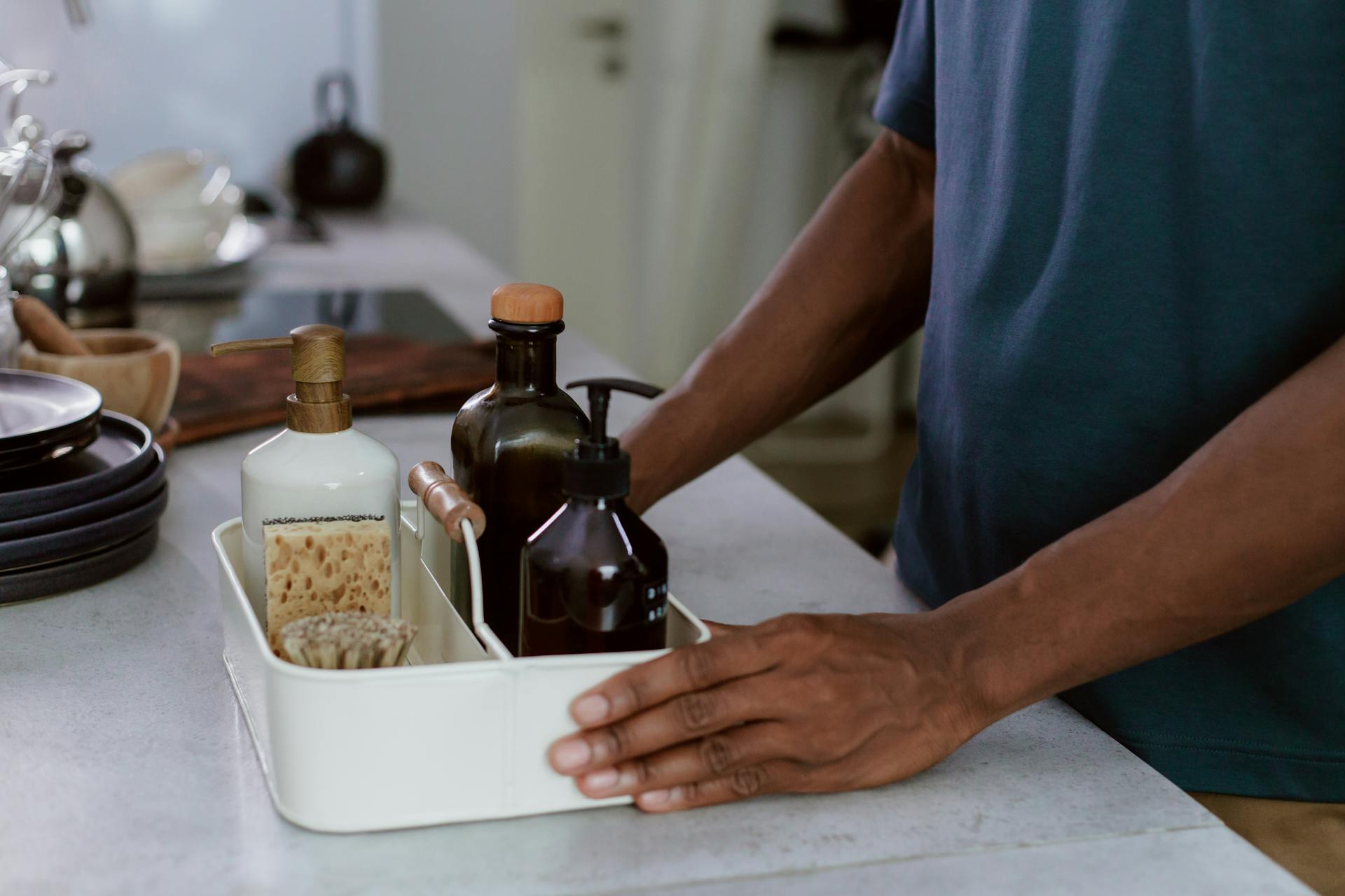 Close-up View of Man Holding Organizer for Cleaning Products