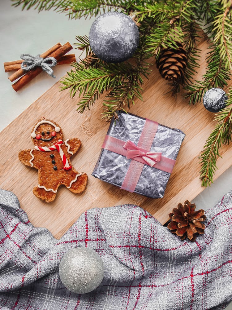 Still Life With Wrapped Christmas Present Gingerbread Cookie And Cinnamon