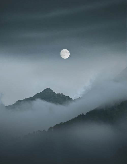 Full Moon over Mountain Covered With Clouds