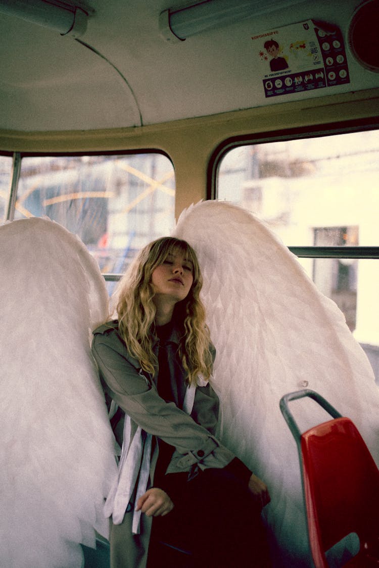 Blond Woman With Long Hair Sitting On City Bus And Posing As Angel