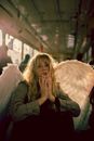 Blond Woman Disguised as Angel Riding on City Bus