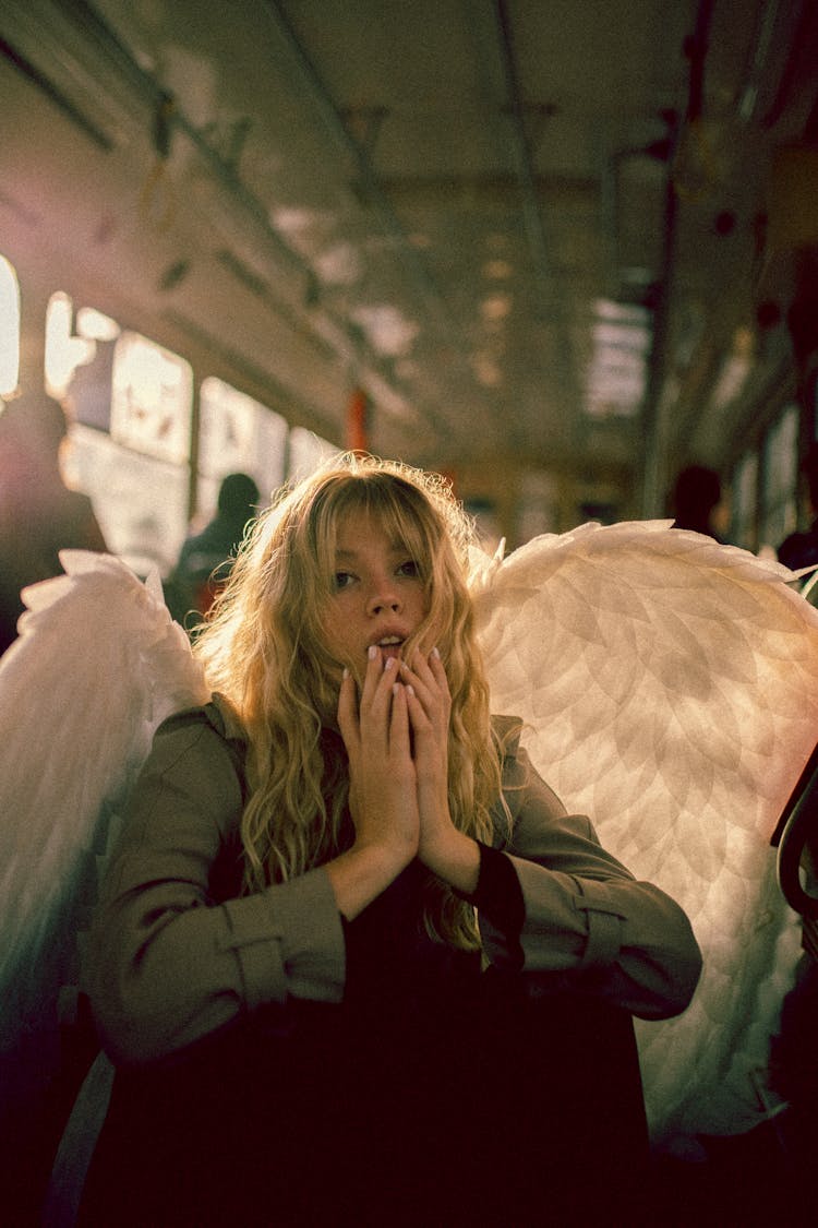 Blond Woman Disguised As Angel Riding On City Bus