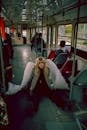 Young Blond Woman on Bus Posing as Angel with White Wings