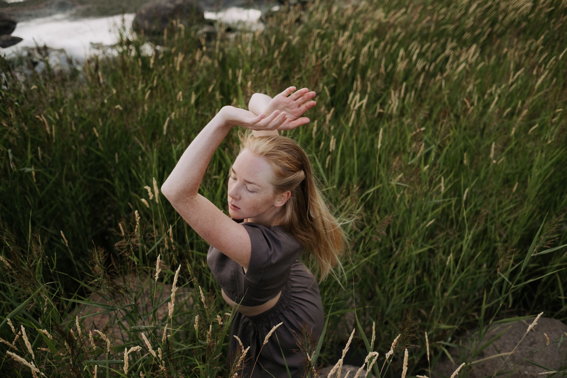 冥想教學如何強化情緒管理:實用技巧與益處 A young woman dances with grace surrounded by lush greenery, embodying peace and harmony with nature.