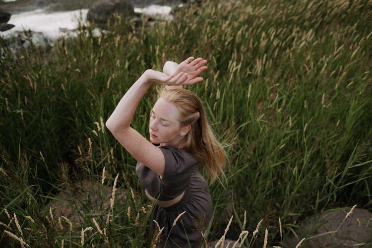 A Young Woman Dancing In A Field