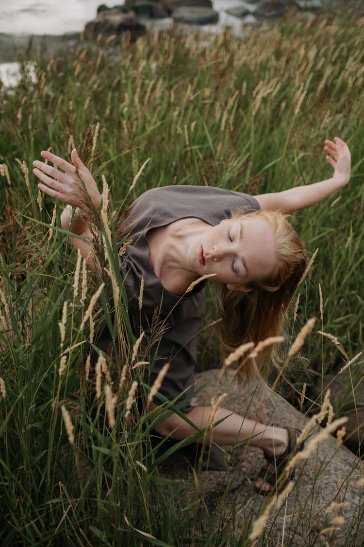 A Young Woman Dancing In A Field