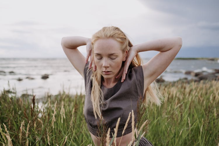 A Woman Dancing On The Field With Her Eyes Closed