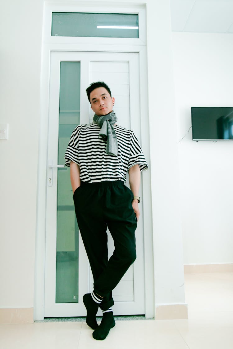 Man In Black And White Striped Shirt Leaning On Door