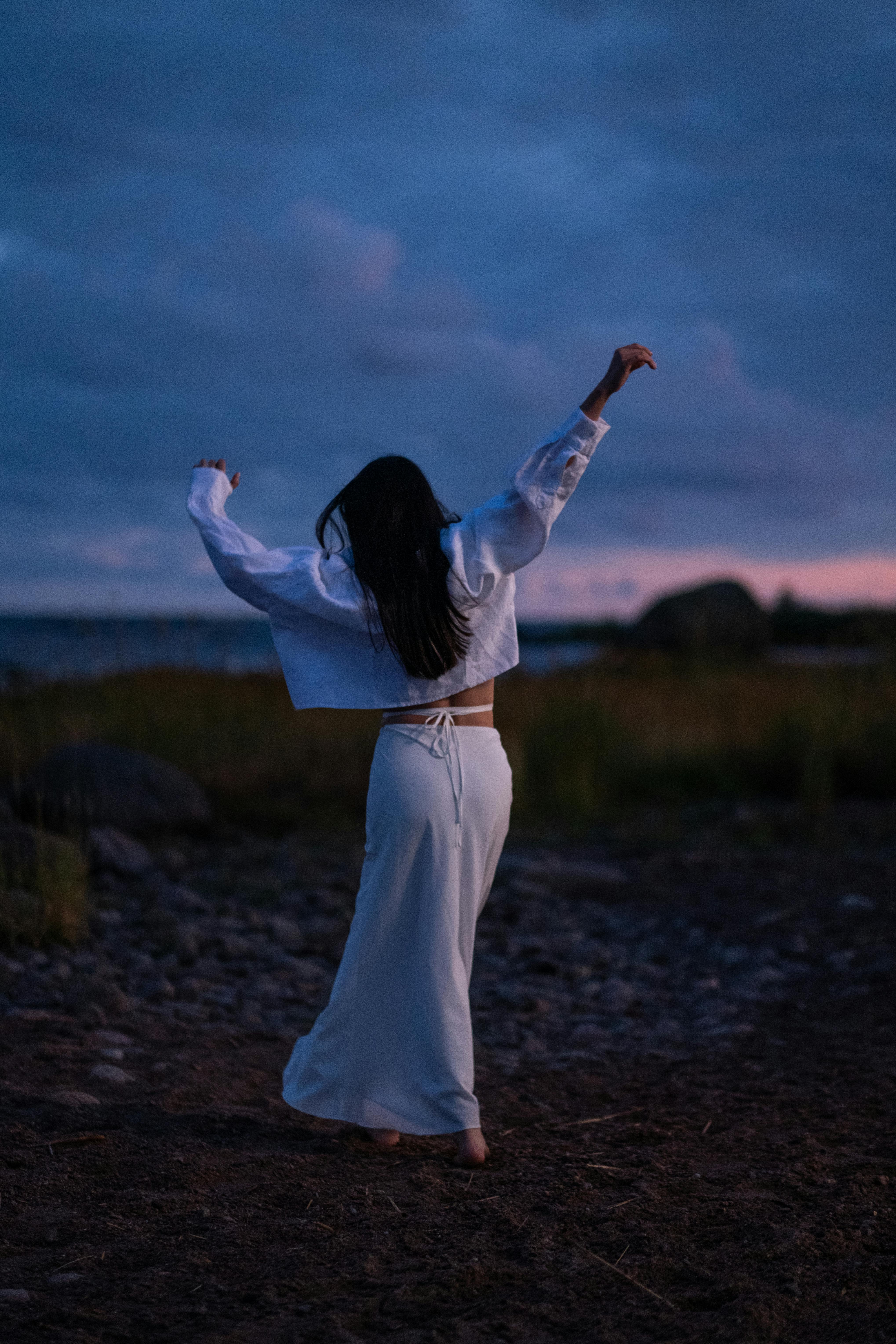 黄昏时分，一名女子在海边自由起舞，拥抱自然与宁静