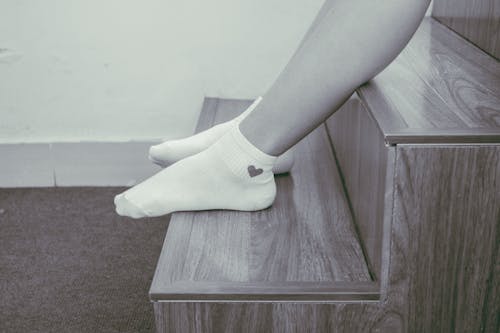 階段に座っている足の靴下を履いている人