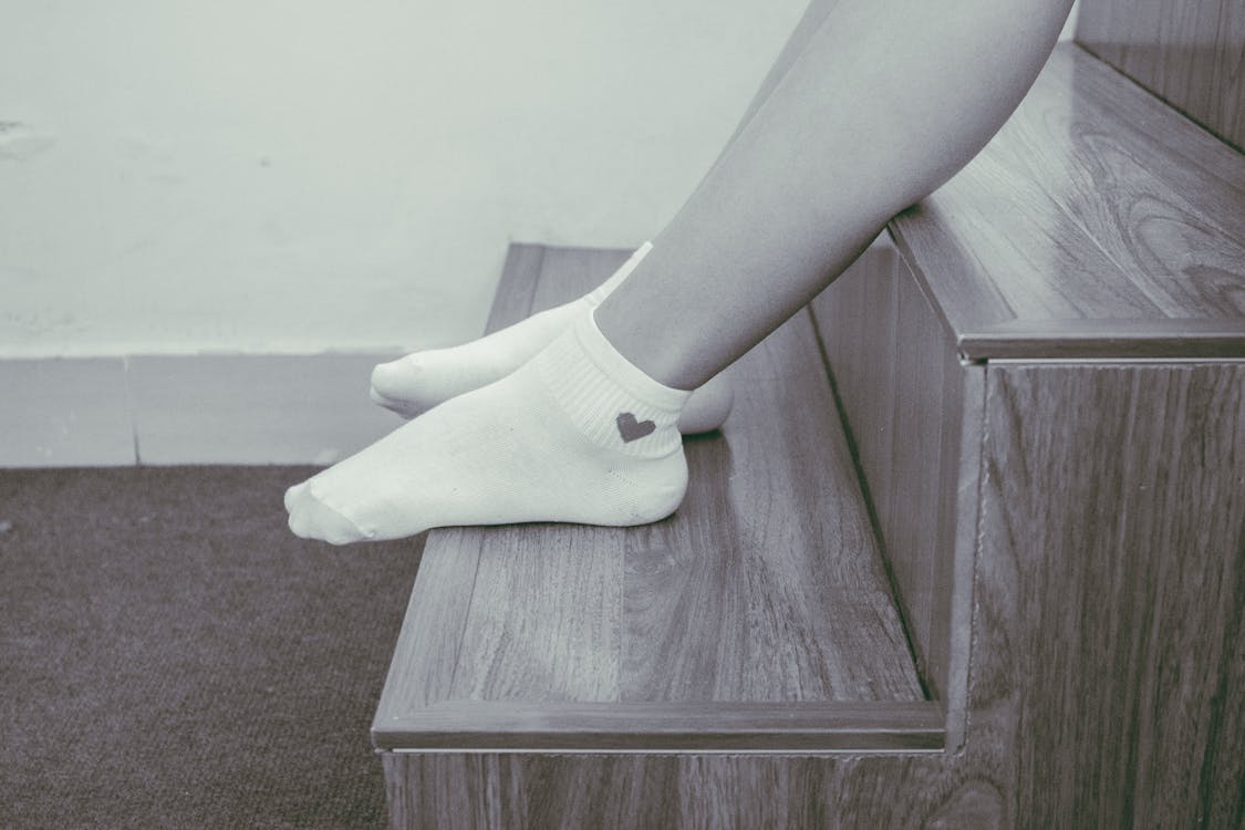 Free Person Wearing Pair of Foot Socks Sitting on Staircase Stock Photo