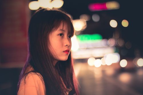 Free Night portrait of a fashionable woman with bokeh city lights in the background. Stock Photo