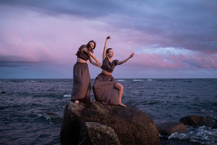 Women Dancing Near The Body Of Water