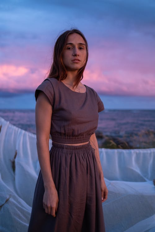 A Young Woman in a Brown Dress by the Seaside