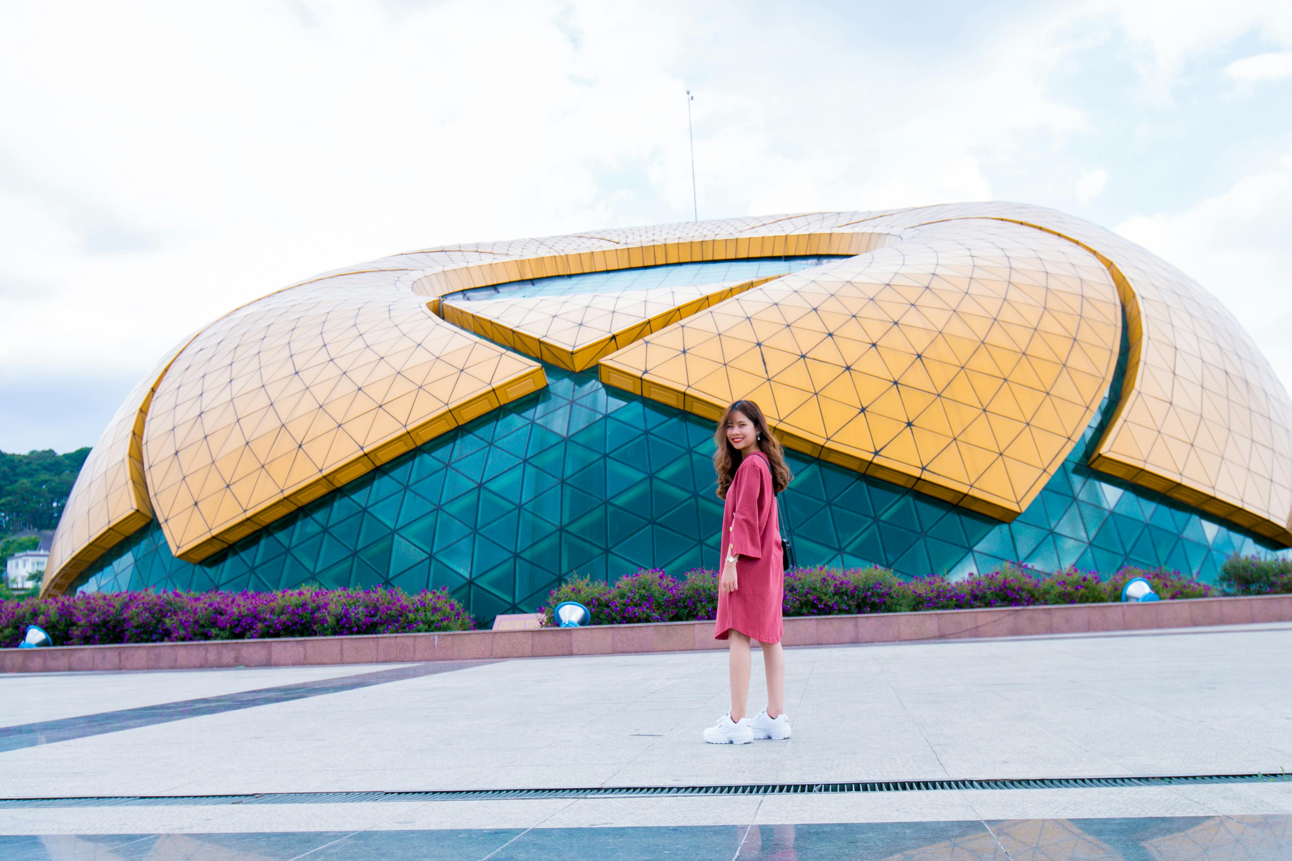 Woman Standing in Front of Yellow and Blue Glass Building