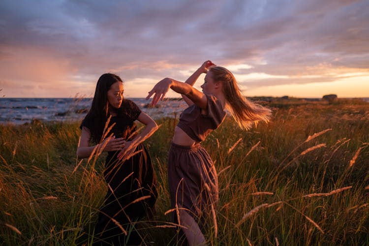 Women Dancing On Grass Field